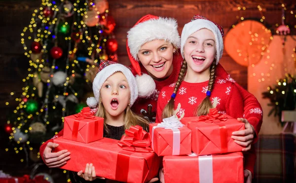 Ein makelloser Weihnachtstag. kleine Mädchen mit vielen Geschenkschachteln. Weihnachtsmorgen-Routine für Mütter. Mama umarmt Töchter in der Nähe des Weihnachtsbaums. Glückliches Familienkonzept. Wunderbare Momente Weihnachten — Stockfoto