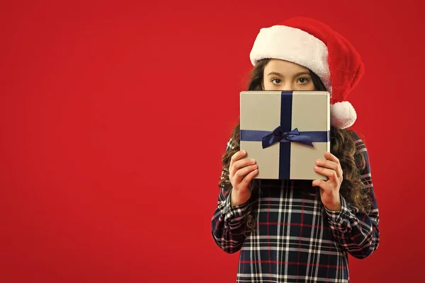 Fiesta de año nuevo. Chico Santa Claus. Compras de Navidad. Regalo para Navidad. Infancia. Niña con sombrero rojo de santa. Felices fiestas de invierno. Niña pequeña. Qué agradable sorpresa. —  Fotos de Stock