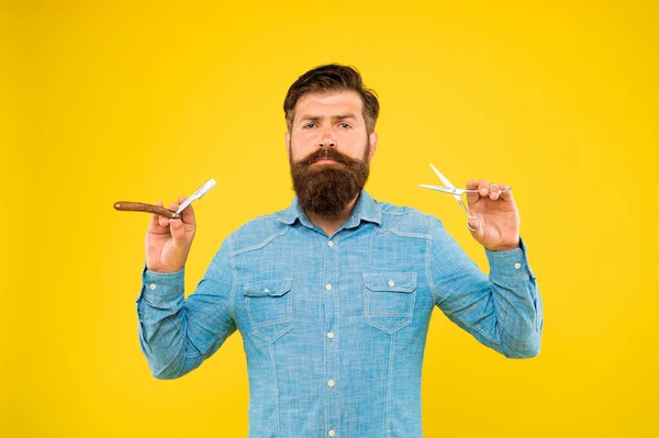 Barba y bigote. Hipster con barba larga y bigote de pelo de fondo amarillo. Hombre barbudo sosteniendo herramientas de aseo de barba. Formado y peinado de barba en barbería — Foto de Stock