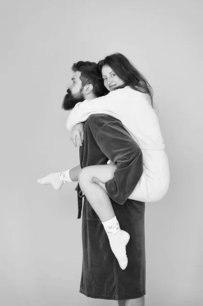 Couple en peignoirs s'amuser. Confiance et soutien. Le véritable amour. Restons à la maison. Ce sont les gens les plus proches. Support en tout temps. Support fiable. Beau jeune homme piggyback belle femme — Photo