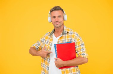 İngilizce öğreniyorum. Eğitim teknolojisi. Çalış. Ses kitabı konsepti. Dünya çapında bilgi erişimi. Ses kütüphanesi. Başka bir çalışma şekli. Yakışıklı üniversite öğrencisi kulaklıkları. Dil çalış