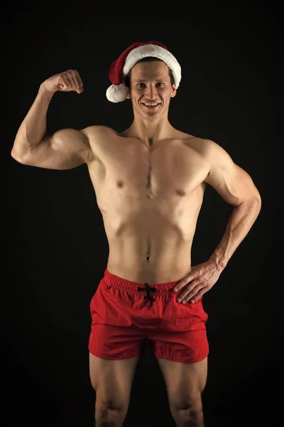 Babbo Natale per ragazze adulte. L'atleta indossa il cappello da Babbo Natale. Sexy atletica macho petto muscolare in cappello di Babbo Natale. Se tu fossi cattiva. Bel concetto di Babbo Natale. Macho busto muscolare posa con fiducia — Foto Stock