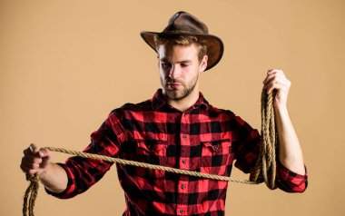 Kement ustası. Çiftlikte kareli gömlek. Batı kovboy portresi. Kement ipli bir kovboy. Batı. Vahşi batı rodeosu. Şapkalı adam. Klasik tarz adam. Vahşi Batı eski kovboy