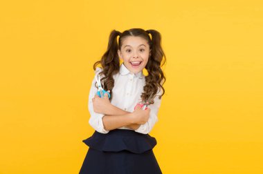 Çocuk deli gibi kesilmeye hazır. Sarı arka planda elinde makas tutan mutlu küçük çocuk. Resmi okul üniformasıyla gülümseyen küçük bir çocuk. Sanat derslerinde öğrenen neşeli kadın çocuk.