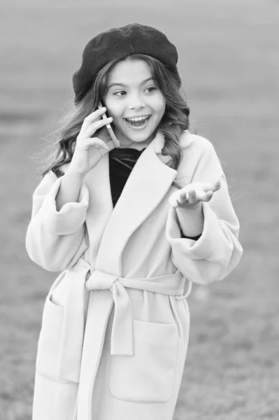 Helt nöjd. höstsäsongen. lycklig barndom. litet barn med telefon. skönhet i höst kappa. glad liten flicka i gult päls. parisiska Girl Kid i franska Beret talar på telefon. höstens mode — Stockfoto