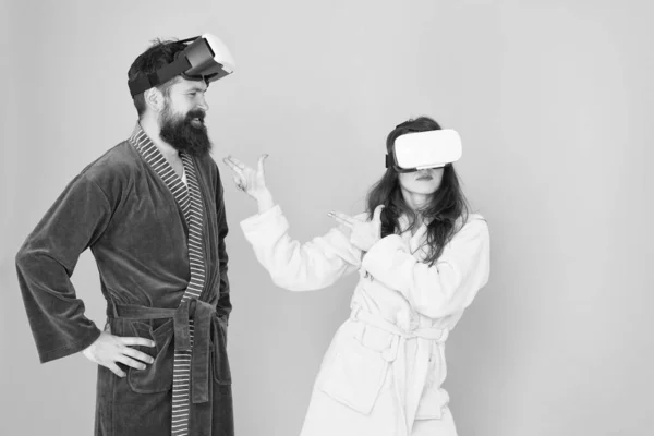 El futuro está más cerca de lo que crees. Hombre y mujer exploran la realidad virtual en casa. Tecnología VR y futuro. Comunicación VR. Emocionantes impresiones. Pareja en albornoces usan gafas VR. Juegos y entretenimiento — Foto de Stock