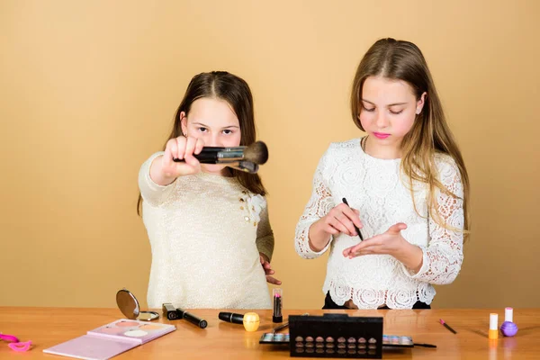 Children little girls choose cosmetics. Makeup store. Experimenting with style. Makeup courses. Makeup art. Explore cosmetics bag concept. Salon and beauty treatment. Just like playing with makeup