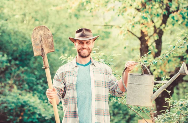 happy earth day. Eco living. Eco farm. Harvest. sexy farmer hold shovel and watering can. farming and agriculture. Garden equipment. muscular ranch man in cowboy hat. Taking good care of plants