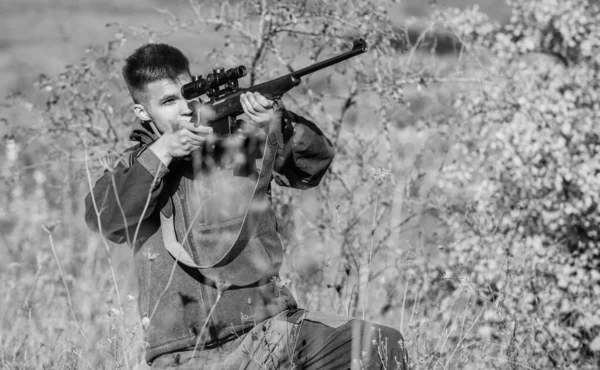 Aiming skills. Hunter hold rifle. Hunting permit. Bearded hunter spend leisure hunting. Hunting equipment for professionals. Hunting is brutal masculine hobby. Man aiming target nature background — Stock Photo, Image