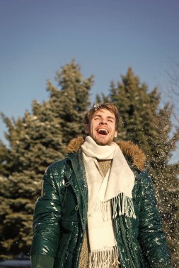 Hava aydınlık kış günü kar taneleri. Kış moda kavramı. Adam tıraşsız giyim sıcak ceket kürk ve eşarp karlı doğa arka plan ile. Adam güneşli kış günü tadını çıkarın. Hipster yürüyüş karlı kış günü