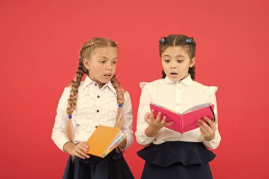 Okumak kapıları açar. Kırmızı arka plan üzerine kitap okuyan küçük çocuklar. Sevimli küçük kızlar okulda okumayı öğrenirler. Sevimli öğrenciler önemli bilgileri öğrenmek için okuma