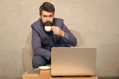 Mobil tarzda. Onun sıcak içecek ve mobil internet zevk sakallı adam. Mobil cihaz ile işadamı iş yerinde çay veya kahve içme. Mobil ofiste laptop çalışan harika insanlar içinde hipster