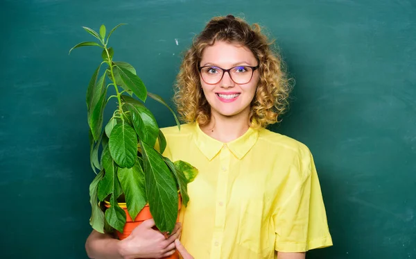 Environmental activities. teacher woman in glasses at biology lesson. environmental education. tree of knowledge. happy student girl with plant at blackboard. school nature study