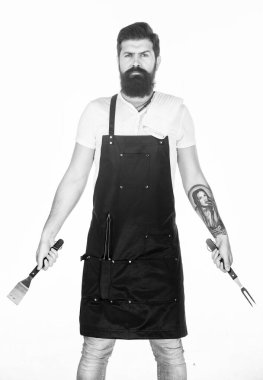 Yemek pişirmek ve servis yapmak için hazır. Elinde çatal ve spatula olan sakallı adam. Barbekü pişirme için mutfak araçları. Paslanmaz çelik mutfak gereçleri tutan hipster. Pişirme aracı seti kullanarak ızgara pişirmek