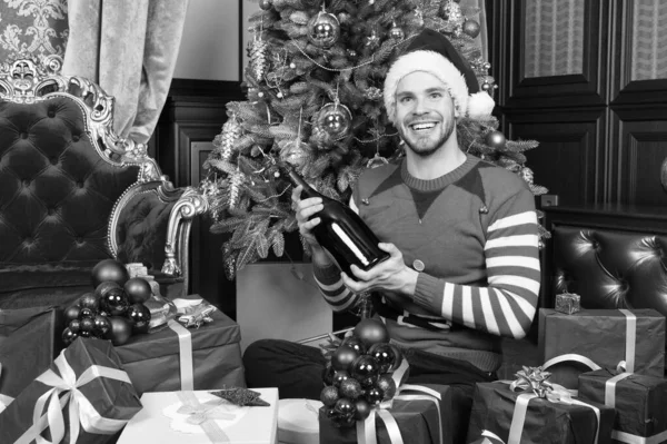 Prettige kerstdagen en gelukkig Nieuwjaar. Gelukkig man met Nieuwjaar geschenkdozen. Man in santa hat greep nieuwe jaar presenteert. Guy viert Nieuwjaar thuis. Hoop die uw vakantie zijn gevuld met plezier — Stockfoto