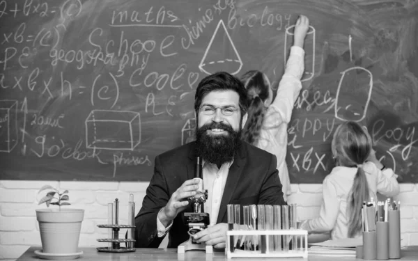 School teacher of biology. Man bearded teacher work with microscope and test tubes in biology classroom. Biology plays role in understanding of complex forms of life. Explaining biology to children