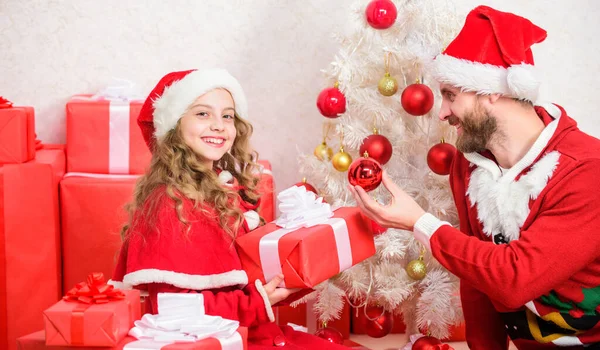 Christmas gift for child. Make your childs holiday extra special this year. Father christmas concept. Dad in santa costume give gift to daughter cute kid. Happy childhood. Christmas family holiday