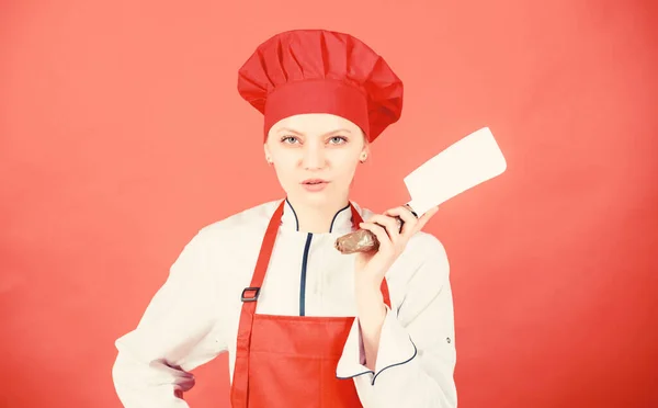 Žena v kuchařském klobouku a zástěře. profesionální kuchař v kuchyni. Kuchyně. Řezník krájí maso. šťastná žena vaří zdravé jídlo podle receptu. Žena v domácnosti s kuchyňským nožem. Čas na večeři — Stock fotografie
