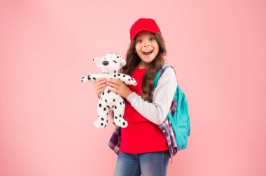 Oyuncak dükkanı küçük şehirliler için harikadır. Oyuncakçıdan alışveriş yapan mutlu küçük kız. Pembe arka planda oyuncak köpeği olan küçük bir çocuk gülümsemesi. Bebek malzemeleri dükkanı. Dükkan ziyaret edilmeli, kopyalama alanı.