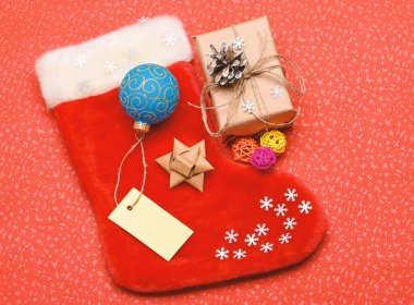 Noel çorap çorap çanta şeklinde. Aile gelenekleri tutun. Çorap stuffers fikir. Noel Baba Noel hediye kutusu ile çorap. Noel çorap kırmızı arka plan üstten görünüm. Geleneksel Noel özniteliği