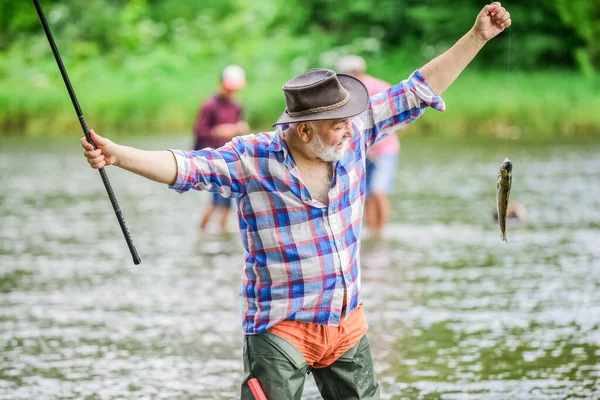 Fai del tuo meglio. attività sportiva e hobby. Esche di trota. Pescatore barbuto in pensione. pesca d'altura. weekend estivo. pescatore con canna da pesca. Pothunter. uomo cattura il pesce. uomo maturo pesca — Foto Stock