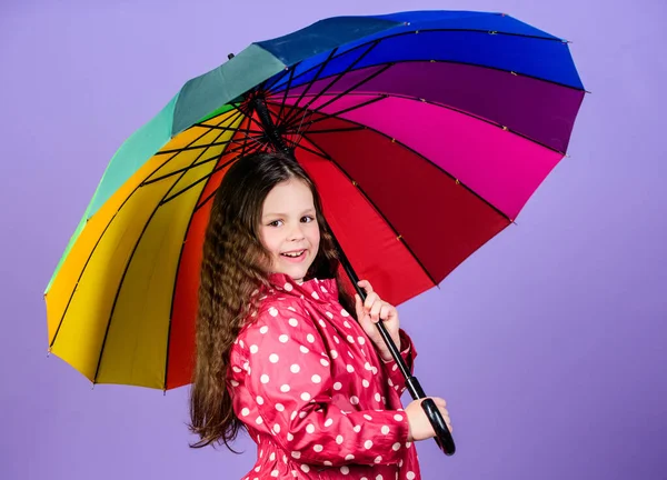 Světlý deštník. Být duhou v někom mraku. Zábavný den. Šťastnou procházku pod deštníkem. Užijte si déšť. Holčička šťastně drží barevný duhový deštník. Deštivé počasí se správným oblečením — Stock fotografie