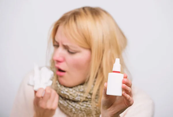Dispenser bottle. Sick woman spraying medication into nose. Treating common cold or allergic rhinitis. Cute woman nursing nasal cold or allergy. Unhealthy girl with runny nose using nasal spray — Stock Photo, Image