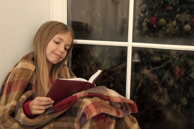 Mutlu tatil için peri masalı. Küçük okuyucu pencere pervazına ekose otur sarılı. Küçük kız Noel hikaye okuma keyfini çıkarın. Küçük çocuk Noel arifesinde kitabını okudum. Çocuk kitabı. Sihirli Noel ruhu
