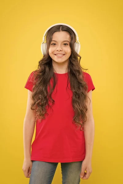 Jedyna muzyka, która się liczy. Urocza dziewczyna ciesząca się muzyką na żółtym tle. Małe dziecko słuchające muzyki w słuchawkach stereo. Edukacja muzyczna dla małych dzieci — Zdjęcie stockowe