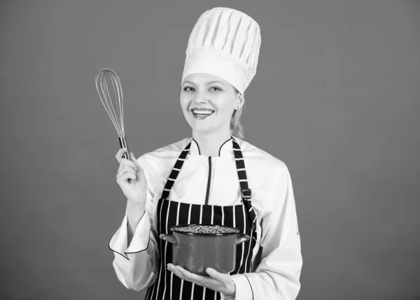 Very easy to use. Professional cook smiling with pot and wire whisk. Cute kitchen maid with stainless steel whisk and mixing bowl. Happy cook holding balloon whisk and cooker