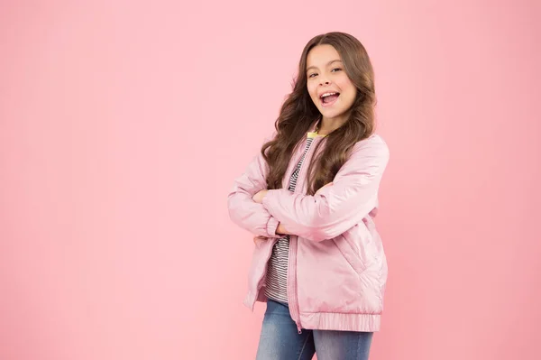 Модний одяг тримає охолодження. Щаслива дитина з модним осіннім виглядом на рожевому тлі. Маленька дівчинка посміхається в модному пальто. Модний і стильний простір копіювання — стокове фото