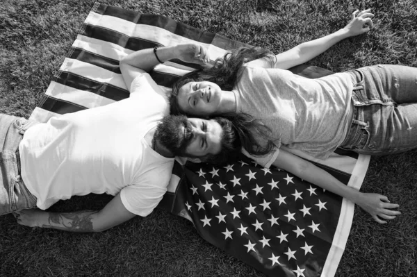 Geschiedenis van Amerika. Amerikaanse patriottische bevolking. Amerikaans echtpaar ontspannen op USA vlag buitenshuis. Onafhankelijkheidsdag. Nationale feestdag. Bearded hipster en meisje in de liefde. 4 juli. Amerikaanse traditie — Stockfoto