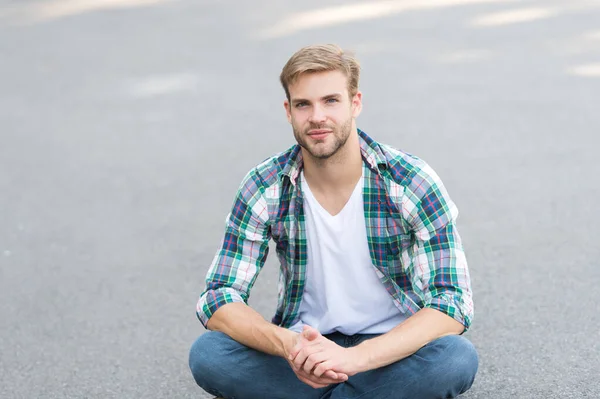 Mantente relajado. Hombre guapo camisa a cuadros. moda masculina. estudiante relajarse en la carretera. macho chico al aire libre. Estilo callejero. Hombre, siéntate. Un estudiante despreocupado. tiempo libre. moda de verano — Foto de Stock