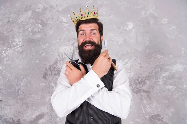 Oh, Dios mío. Peluquero con cara barbuda sorprendida. El gran jefe barbudo lleva corona. El barbudo sostiene tijeras y navajas. Herramientas de barbero. Peluquería de lujo. Peinado de moda para hipster barbudo — Foto de Stock