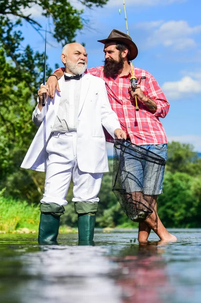 La pesca como vacaciones. Hobby y recreación. Pescador de traje formal. Atrapar con éxito. Amigos pescando. Elegante hombre barbudo y brutal pesca hipster. Un fin de semana perfecto. Día de la familia. Vacaciones de verano — Foto de Stock