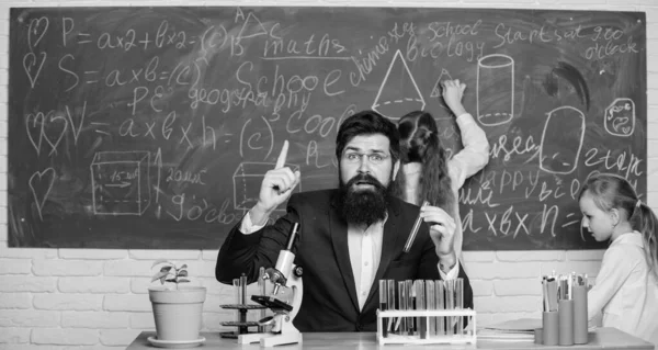 Man bearded teacher work with microscope and test tubes in biology classroom. School teacher of biology. Explaining biology to children. Biology plays role in understanding of complex forms of life