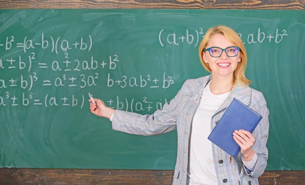 Professor da escola explicar as coisas bem e tornar o assunto interessante. O que faz um grande professor. Ensinar a atividade multifacetada complexa. Professor mulher inteligente com livro explicar tópico perto quadro — Fotografia de Stock