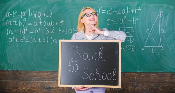 Professeur heureux d'accueillir les élèves. Commencez l'année scolaire. Meilleures façons d'accueillir les élèves à l'école. La maîtresse garde l'inscription au tableau noir à l'école. C'est encore l'heure de l'école. — Photo