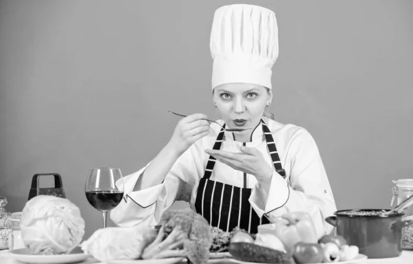 Gourmet main dish recipes. Delicious recipe concept. Girl in hat and apron. Cooking healthy food. Fresh vegetables ingredients for cooking meal. Professional cooking tips. Woman chef try taste food
