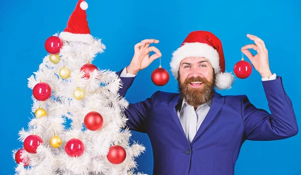 Christmas atmosphere spread around. Holidays meant for fun. Man bearded wear formal suit and santa hat. Businessman join christmas celebration. Santa hold christmas ball decoration. Merry christmas