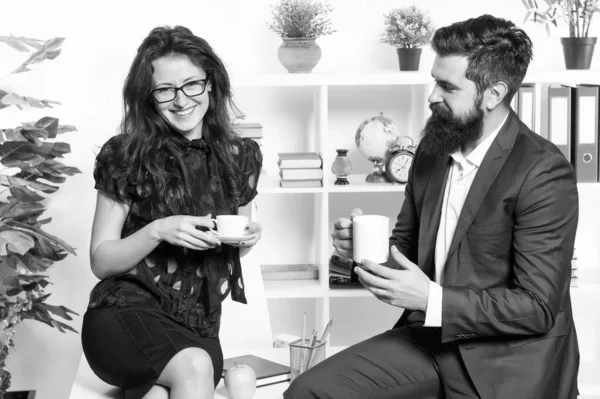 Een werkende lunch vergadering. Collega's praten tijdens de werklunch. Sexy vrouw en bebaarde man genieten van lunchpauze in kantoor. Bedrijfsmedewerkers die thee of koffie drinken voor de lunch — Stockfoto