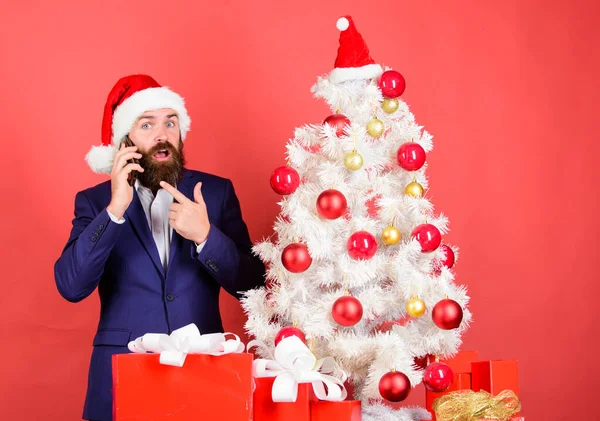 Vytvořte Santa nazvat tyto Vánoce. Muž ve vousatém obleku a Santa klobouku drží telefon. Udělat vánoční kouzlo s personalizované volání ze Santa. Vánoční hovor. Manažer blahopřeje kolegům mobilní hovor — Stock fotografie