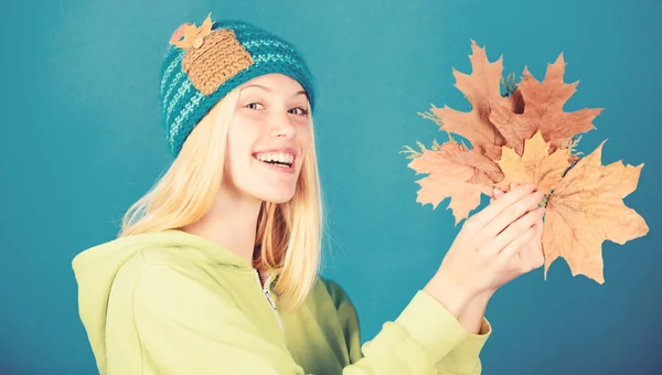 Enjoy autumn season. Autumn skincare tips. Bright moment. Skincare and beauty tips. Active leisure and rest autumn season. Woman wear knitted hat hold fallen leaves. Skincare routine for autumn