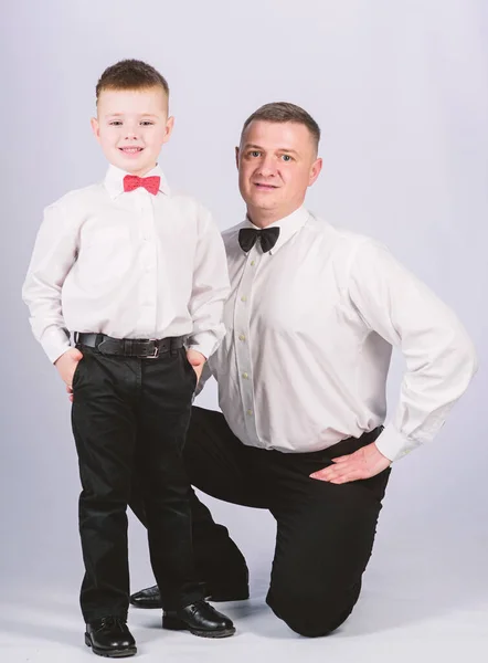 La educación de los caballeros. Evento formal. Hijo pequeño siguiendo el ejemplo de los padres de un hombre noble. La educación de los caballeros. Traje de ropa formal de padre e hijo. Crecer caballero. Papá y niño con pajaritas — Foto de Stock