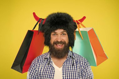 Alışveriş konusunda vahşi. Tam ürün paketleri. Adam sıkı yüz boynuzları ile boğa şapka giymek. Hipster alışveriş bağımlısı veya alışverişkolik. Alışveriş konsepti. İndirimli Guy alışveriş satış sezonu