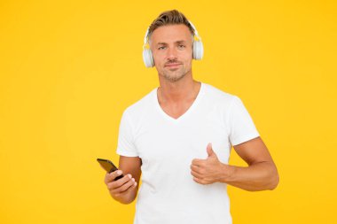 İyi bir şarkı dinle. Guy modern kullanıcı mobil uygulaması. Favori müzik listesi. Müzik aboneliği. Olgun adam müzik dinler modern kulaklıklar ve akıllı telefonlar. Dinleme konsepti. En iyi müzik uygulamaları