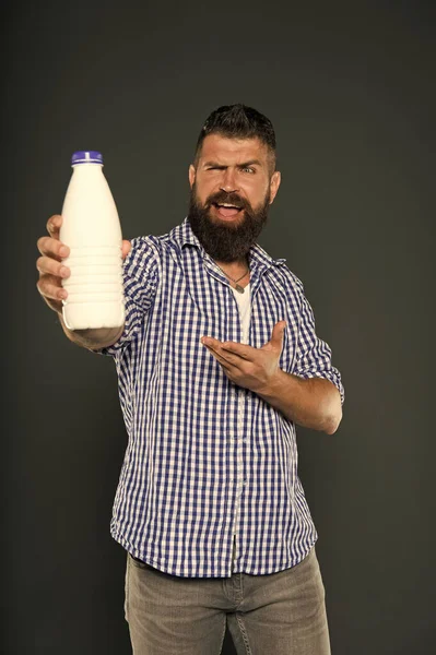 Gesunde Trinkgewohnheiten. fröhlicher Hipster, der auf die Flasche zeigt, um natürliche Milch zu trinken. bärtiger Mann, der Milchprodukte trinkt. Milch trinken für eine bessere Verdauung — Stockfoto