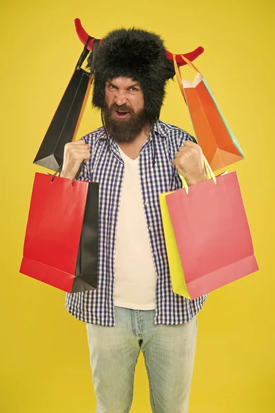 Los precios de venta son bajos, no seas lento. Feliz hipster con cuernos de toro sombrero sosteniendo bolsas de compras después de la venta de temporada. Hombre barbudo sonriendo con compras compradas a la venta. Viernes Negro y Cyber lunes venta —  Fotos de Stock