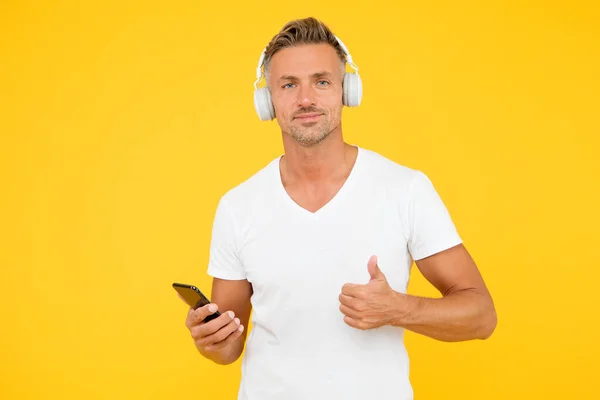 Άκου καλό τραγούδι. Guy σύγχρονο χρήστη mobile εφαρμογή. Αγαπημένη μουσική λίστα. Μουσική συνδρομή. Ώριμος άνθρωπος ακούστε μουσική μοντέρνα ακουστικά και smartphone. Ακρόαση. Καλύτερες μουσικές εφαρμογές — Φωτογραφία Αρχείου