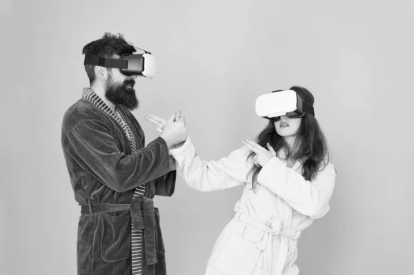 A jövő közelebb van, mint gondolnád. VR technológia és jövő. VR kommunikáció. Izgalmas benyomások. Egy pár fürdőköpenyben visel VR szemüveget. Játék és szórakozás. Férfi és nő fedezze fel a VR otthon — Stock Fotó